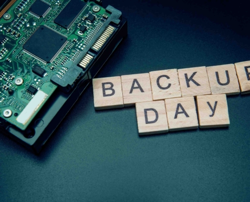 Scrabble Steine formen die Worte "Backup Day" neben Computerplatine